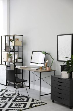 Modern bilgisayarlı, masa başında rahat bir ofis sandalyesi.