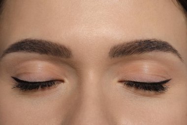 Young woman with permanent makeup of eyes and brows, closeup