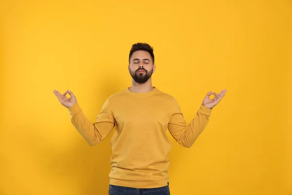Young Man Meditating Yellow Background Zen Concept — 스톡 사진
