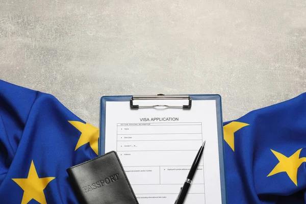 Visa application form, passport, pen and flag of European Union on light grey table flat lay. Space for text