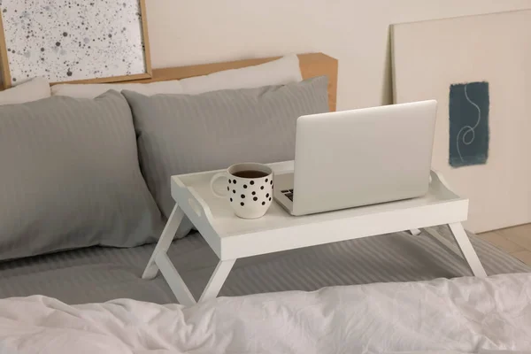 Laptoplu Beyaz Tepsi Masası Yatağın Içinde Bir Bardak Içki — Stok fotoğraf