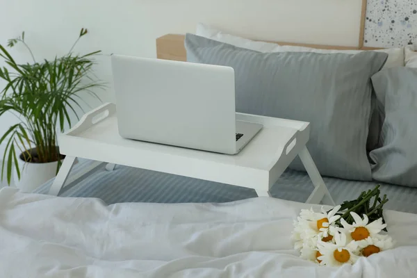 Τραπέζι Λευκό Laptop Και Μπουκέτο Από Όμορφες Μαργαρίτες Στο Κρεβάτι — Φωτογραφία Αρχείου