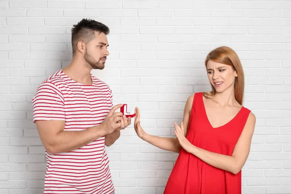 Young Woman Rejecting Engagement Ring Boyfriend White Brick Wall — Stockfoto