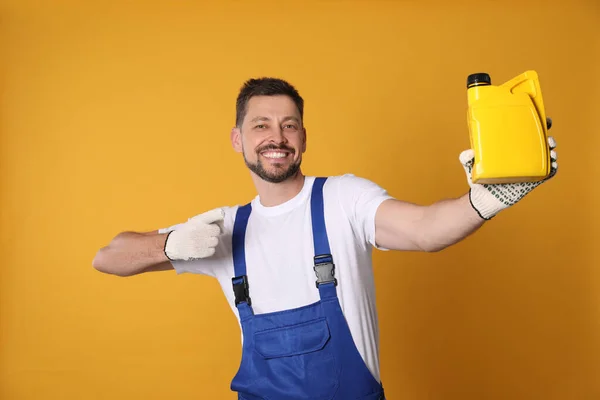 Man Pointing Yellow Container Motor Oil Orange Background — Stockfoto