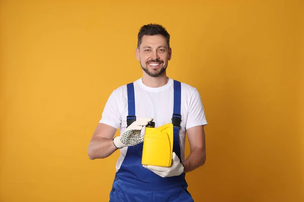 Man Holding Yellow Container Motor Oil Orange Background — Stockfoto