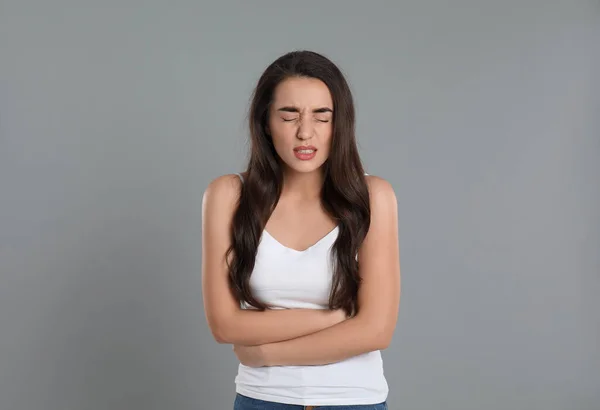 灰色の背景で胃の痛みに苦しんでいる若い女性 食中毒 — ストック写真