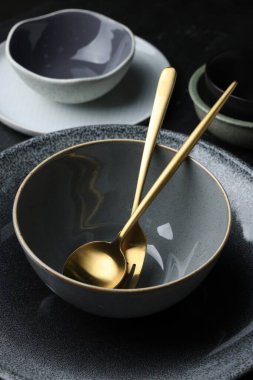 Set of clean tableware on black table