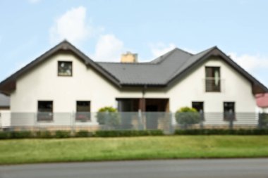 Blurred view of beautiful house behind fence