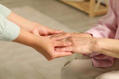 Genç ve yaşlı kadınlar el ele tutuşup, yakınlaşırlar.