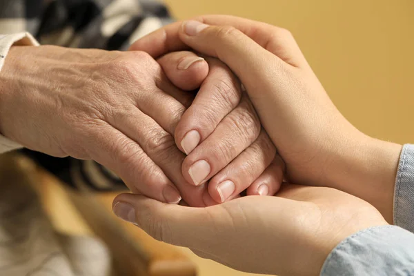 Young Elderly Women Holding Hands Beige Background Closeup — ストック写真