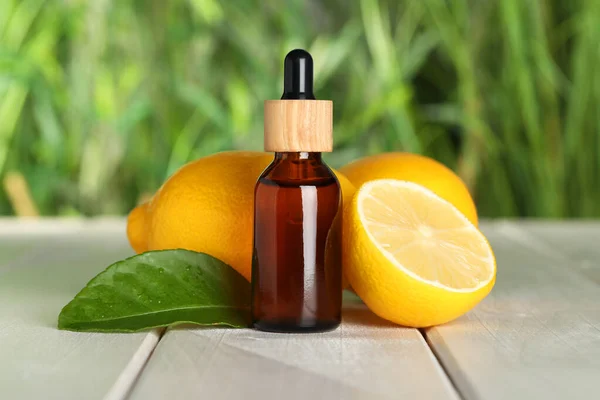 Bottle Essential Oil Lemons Leaf White Wooden Table Blurred Background — Zdjęcie stockowe