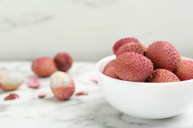 Taze olgun liçi meyveleri beyaz mermer masada seramik kasede. Metin için boşluk