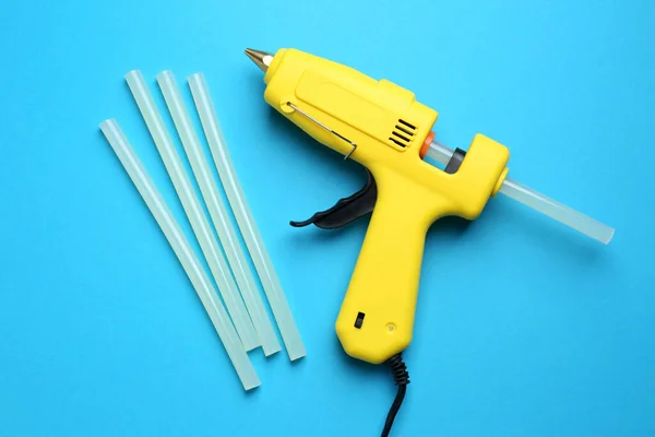 Yellow Glue Gun Sticks Light Blue Background Flat Lay — Foto Stock