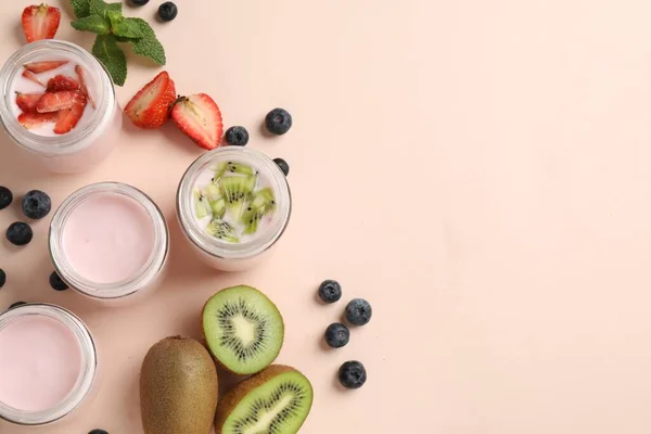 Gläser Mit Frischem Joghurt Und Verschiedenen Früchten Auf Hellrosa Hintergrund — Stockfoto