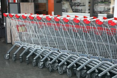 Row of empty metal shopping carts near supermarket outdoors