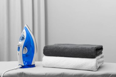 Modern iron and clean towels on board indoors