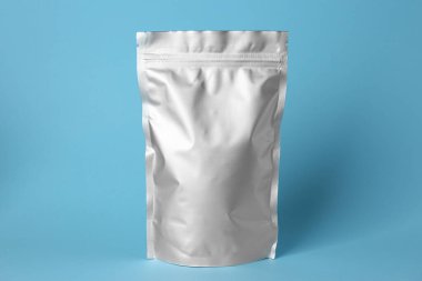 Açık mavi arkaplanda boş bir folyo paketi