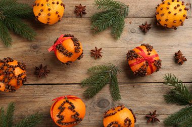 Flat lay composition with pomander balls made of fresh tangerines and oranges on wooden table