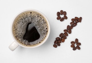 Cup of coffee and beans as percent sign on white background, top view. Decaffeinated drink