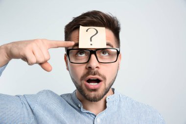 Alnında soru işareti olan duygusal bir adam.