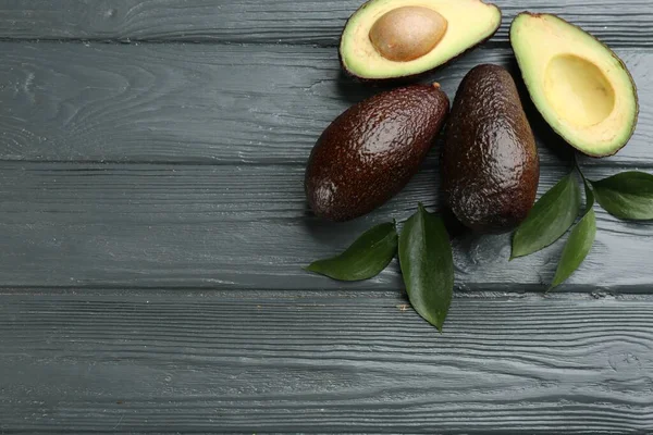 Whole Cut Avocados Green Leaves Grey Wooden Table Flat Lay — Stock Fotó