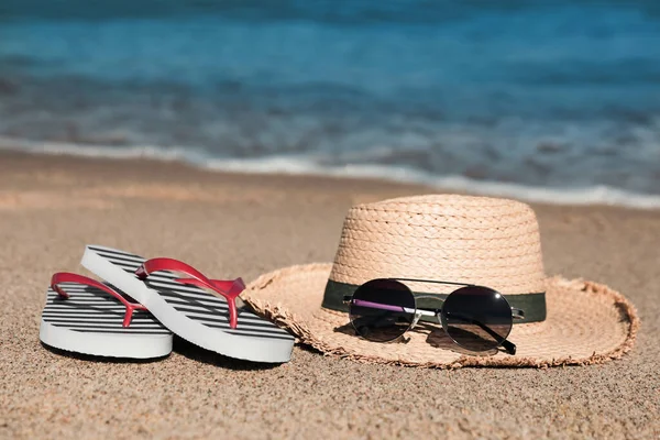 Striped Flip Flops Straw Hat Sunglasses Sandy Beach Sea — Foto de Stock