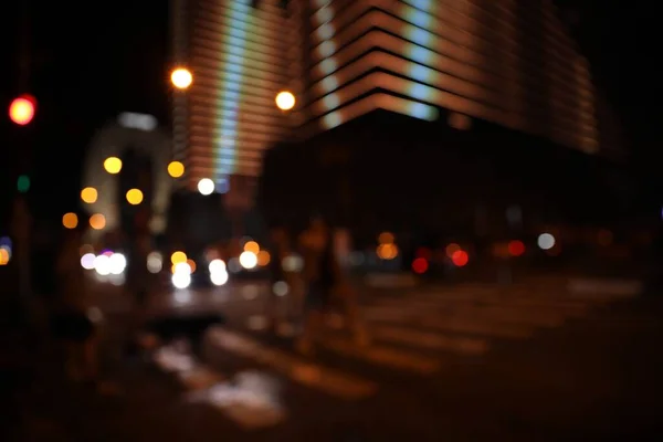 Blurred view of people crossing street in city. Night life