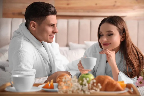 Pareja Feliz Albornoces Desayunando Cama Casa — Foto de Stock