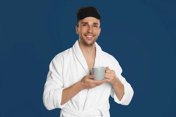 Młody Mężczyzna Szlafroku Filiżanką Kawy Niebieskim Tle — Zdjęcie stockowe