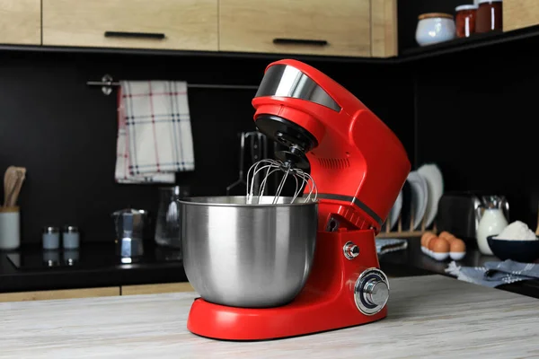 Modern stand mixer on wooden table in kitchen. Home appliance