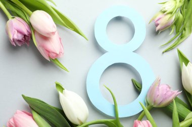 Açık gri zemin üzerinde laleler bulunan 8 Mart kart tasarımı. Uluslararası Kadınlar Günü