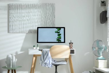 Modern bilgisayarlı, masa başında rahat bir ofis sandalyesi.