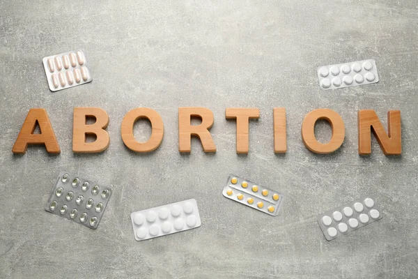 Word Abortion Made Wooden Letters Pills Grey Background Flat Lay — Stockfoto