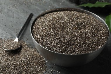 Metal bowl with chia seeds on table