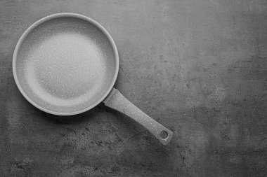 New non-stick frying pan on grey table, top view. Space for text