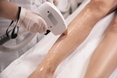 Woman undergoing laser epilation procedure in beauty salon, closeup