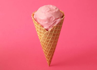 Pembe arka planda waffle külahında leziz dondurma.