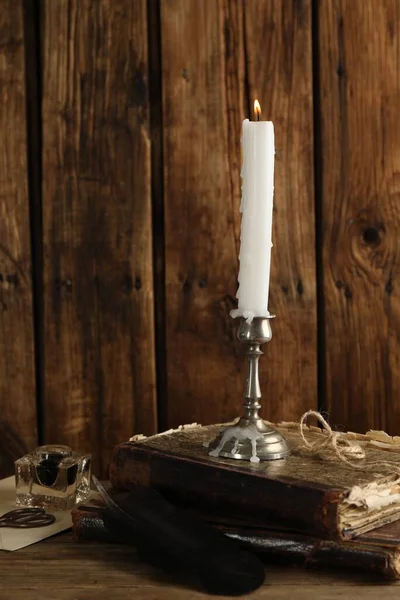 Κομψό Κηροπήγιο Αναμμένο Κερί Και Αρχαία Βιβλία Ξύλινο Τραπέζι — Φωτογραφία Αρχείου