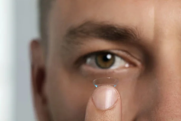 Man Putting Contact Lens His Eye Blurred Background Closeup — Foto Stock
