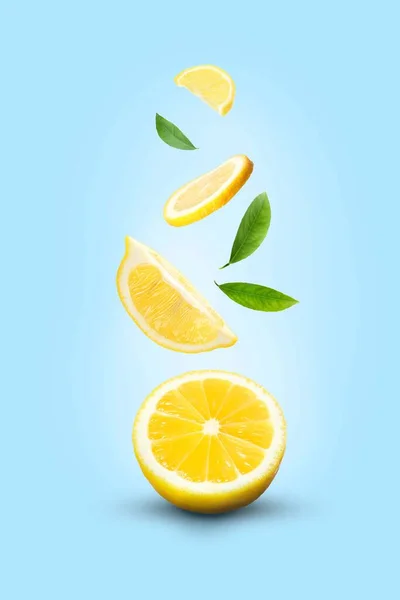 Fresh Ripe Lemons Green Leaves Falling Light Blue Background — Stockfoto