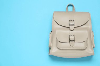 Stylish urban backpack on light blue background, top view. Space for text