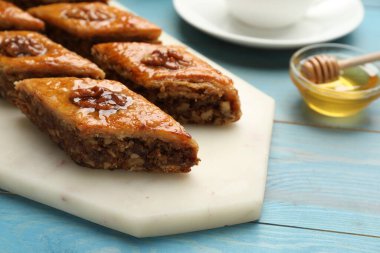 Turkuaz ahşap masada cevizli enfes tatlı baklava, yakın plan.