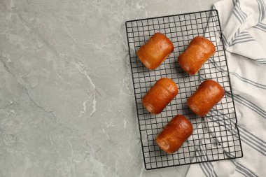 Delicious baked pirozhki on light grey marble table, top view. Space for text