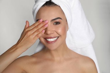 Kafasında havluyla arka planda güzel bir kadın.