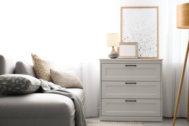 Oturma odasındaki pencerenin yanındaki çekmecelerin modern stil sandığı. İç tasarım