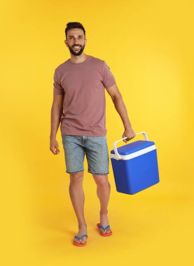 Sarı arka planda havalı kutusu olan mutlu adam.