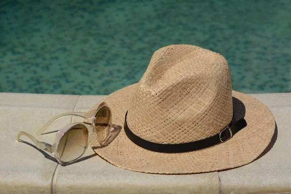 Elegante Sombrero Gafas Sol Cerca Piscina Aire Libre Día Soleado —  Fotos de Stock