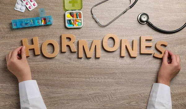 Doctor Making Word Hormones Wooden Letters Table Top View — Stock Photo, Image