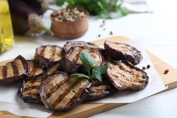 Deliciosas Rodajas Berenjena Parrilla Con Perejil Especias Mesa Madera Blanca —  Fotos de Stock