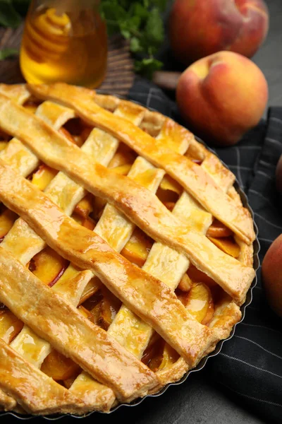 Delicious fresh peach pie on black table